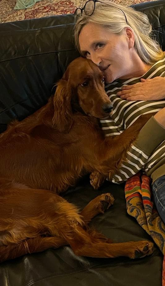 Irish Red Setter von Irish Windlooper's schmiegt sich eng an seine Besitzerin auf der Couch